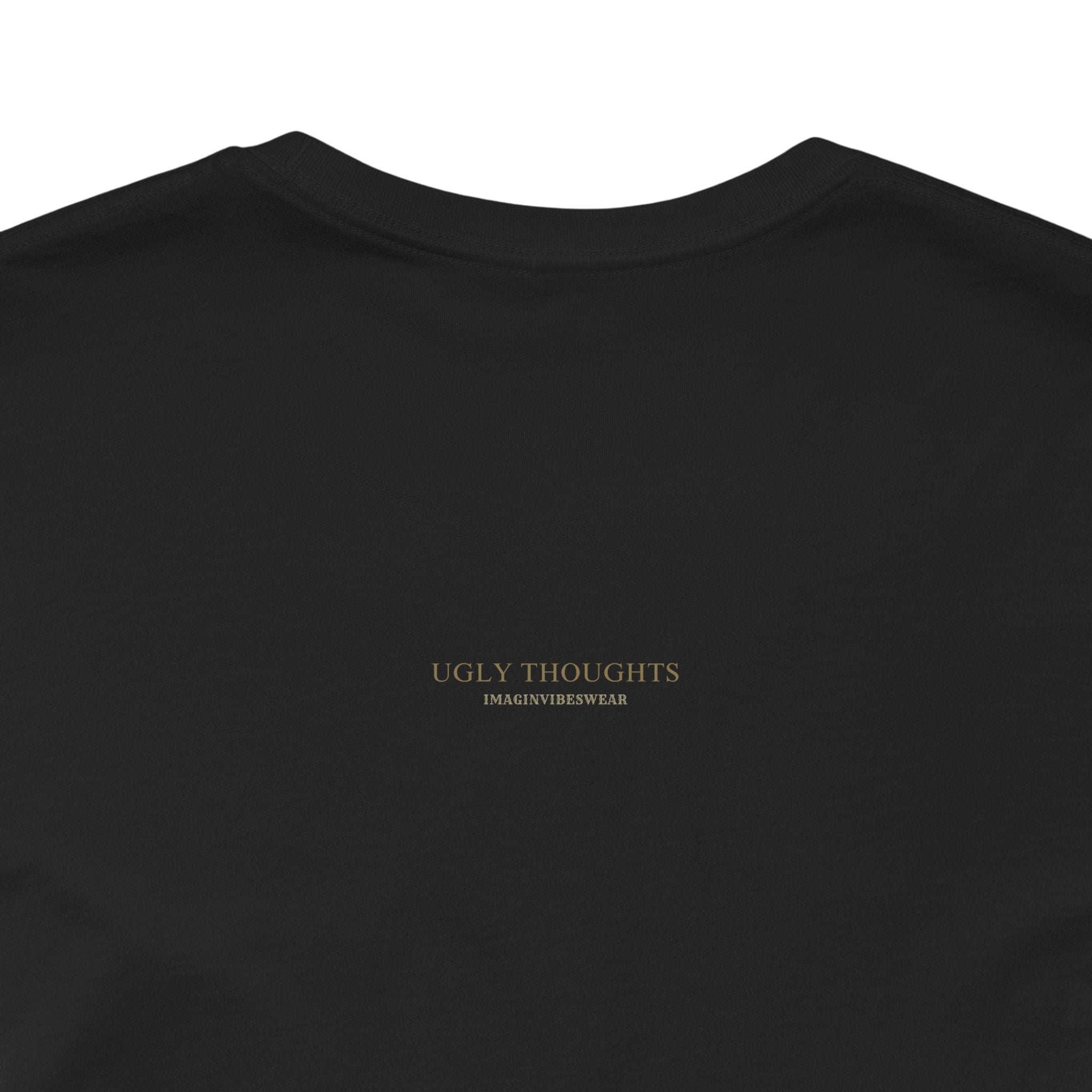 Back view of a black shirt featuring the phrase 'UGLY THOUGHTS' in gold, from Imaginary Vibeswear.