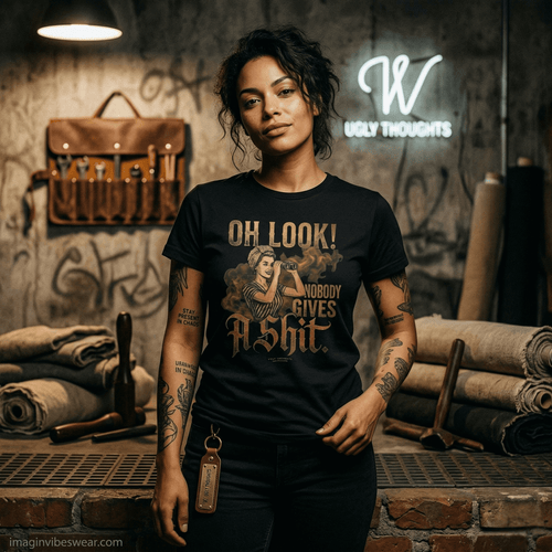 A woman wearing a retro nobody gives a shit shirt with a sarcastic graphic design in a workshop setting.